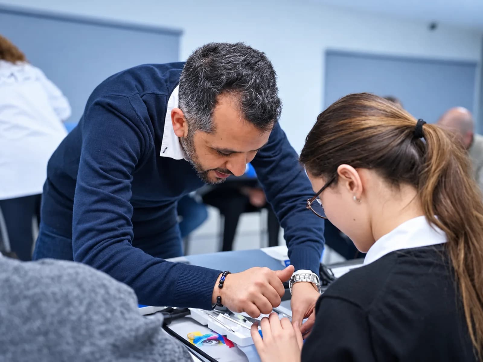 Travaux pratiques sur modèles, formateur au côté d'une participante