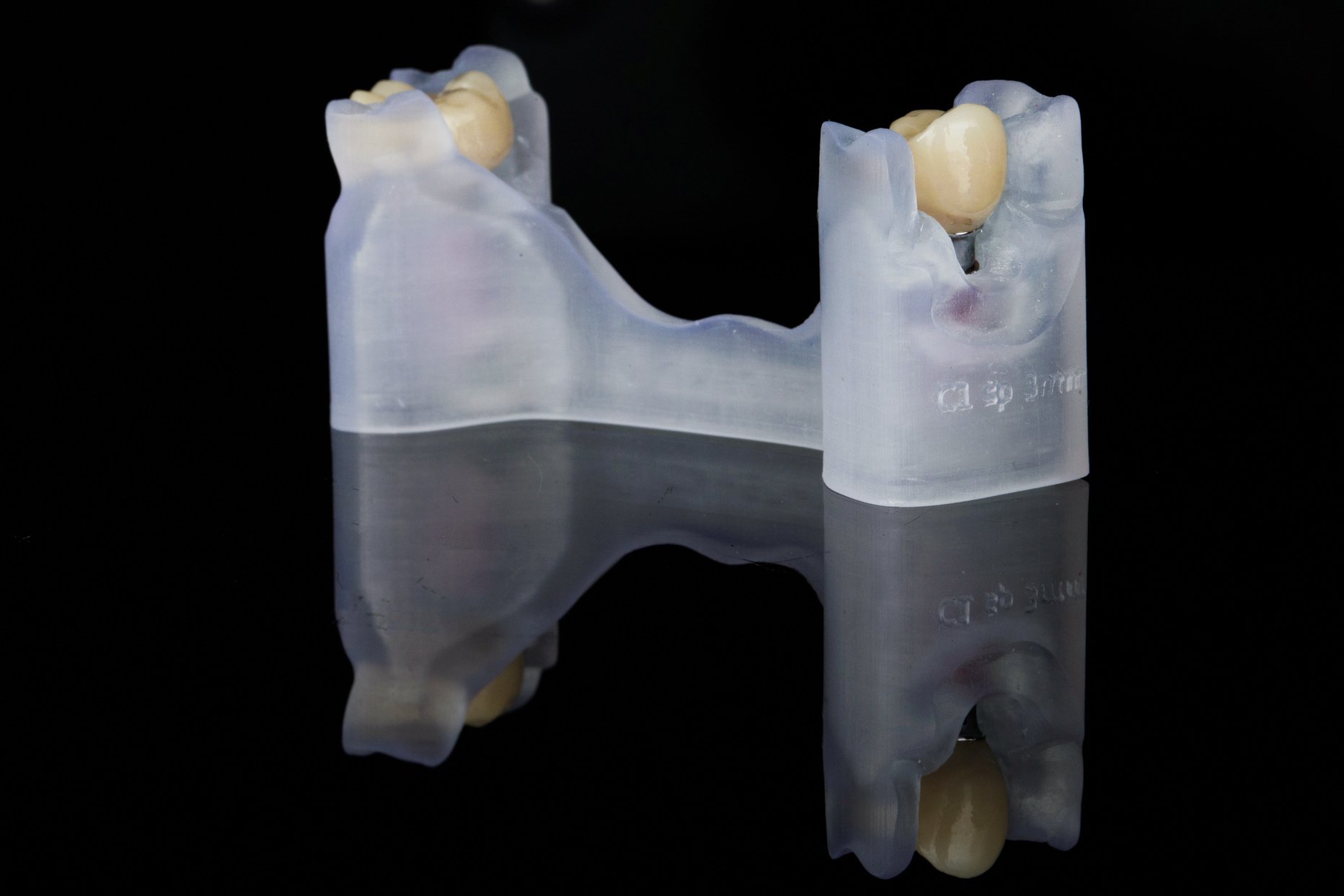 zirconia crowns on a resin model, shot against a black backgroun